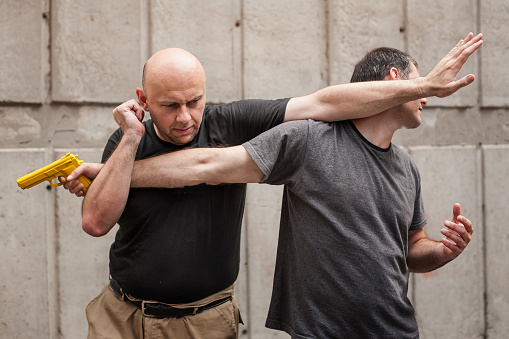 Kapap instructor demonstrates self defense techniques against a gun point. Gun Disarm.