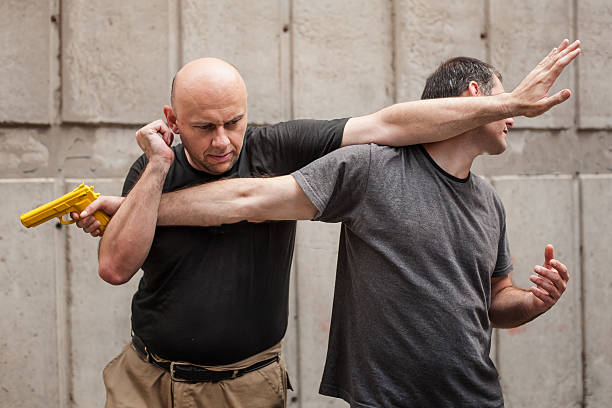 Gun Disarm. Self defense techniques against a gun point. Kapap instructor demonstrates self defense techniques against a gun point. Gun Disarm. self defense stock pictures, royalty-free photos & images