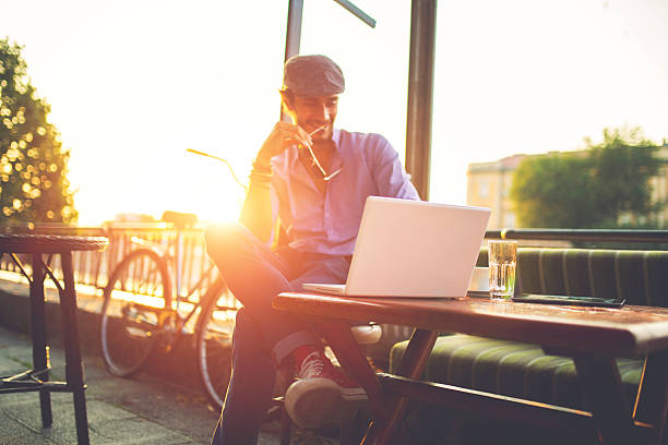 istock Stylish man sitting in a cafe in sunset 619045884