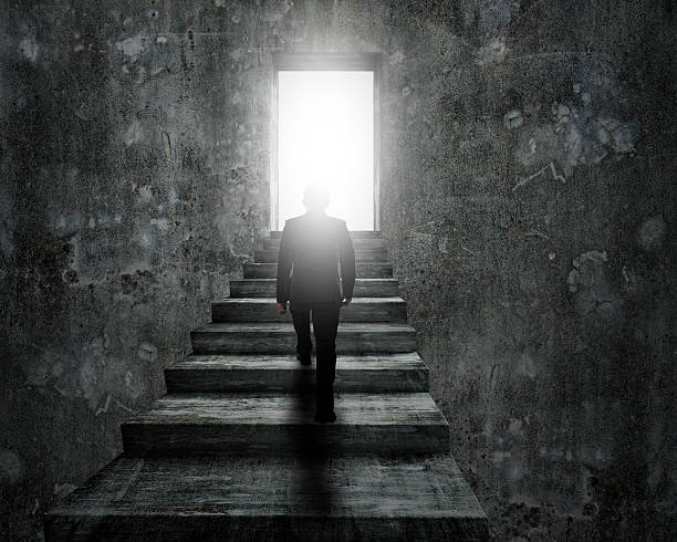 istock Man climbing concrete stairs toward door with bright light. 619046242