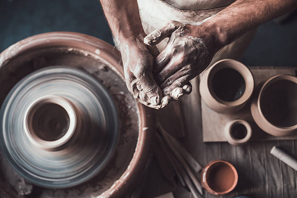Potter at work. Top view of potter standing near pottery wheel and holding hands together pottery photos stock pictures, royalty-free photos & images