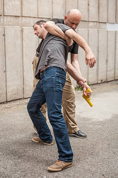 istock Gun Disarm. Self defense techniques against a gun point. 619048350