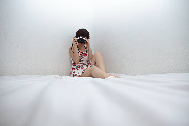 istock Girl sitting on the bed with white sheets. 619048422
