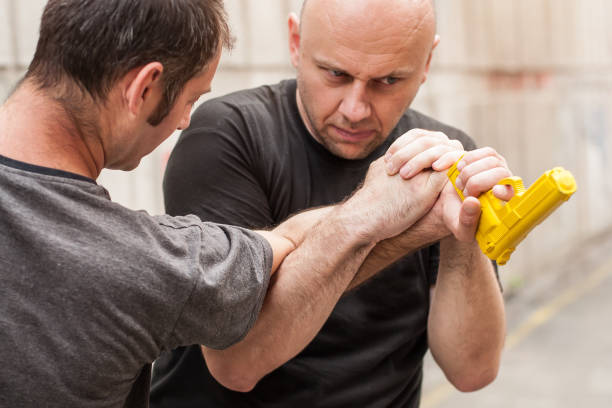 istock Gun Disarm. Self defense techniques against a gun point. 619051088