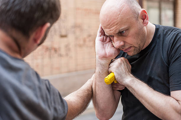istock Gun Disarm. Self defense techniques against a gun point. 619051780