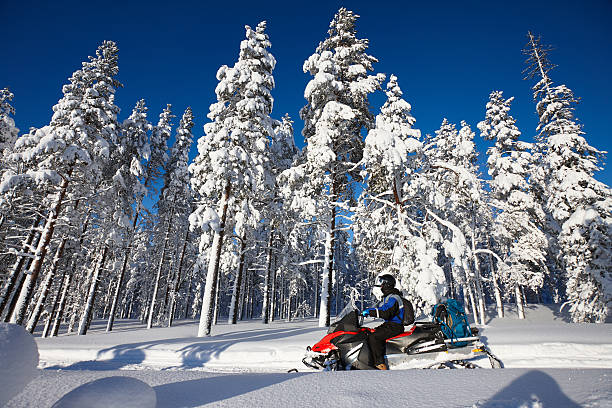 istock Man driving snowmobile in Finland 619052664