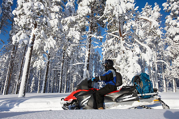 istock Man driving snowmobile in Finland 619052776