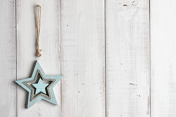 Wooden star-shaped christmas decoration hanging over white fence