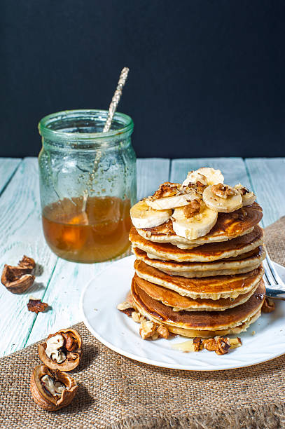 istock Plate with pancakes, banana slices and honey 619053286