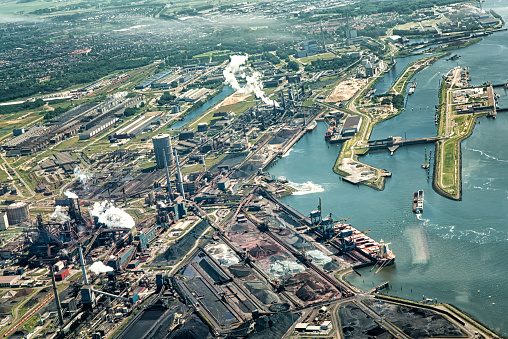 IJmuiden, Netherlands. Aerial view of factory with smoking chimneys and in the background the Noordzee.