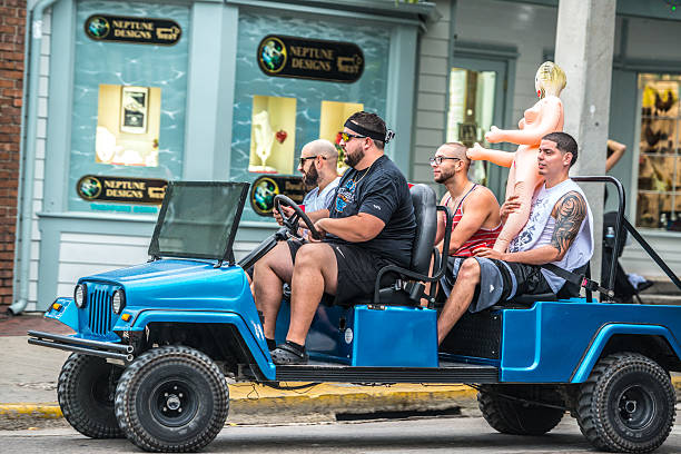 männer mit sexpuppe fahren auf duval street, key west - blow up doll stock-fotos und bilder