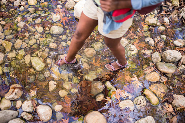 istock Backpacker woman crossing the creek at fall. 619059806