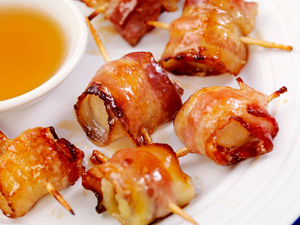 Bacon Wrapped Scallops in a Maple Glaze Grilled Bacon Wrapped Scallops in a Maple Glaze - Photographed on Hasselblad H3D2-39mb Camera bacon wrapped stock pictures, royalty-free photos & images