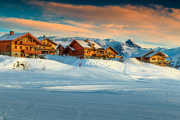 hermosa puesta de sol y complejo turístico de esquí en los alpes franceses, europa - village snow winter france fotografías e imágenes de stock