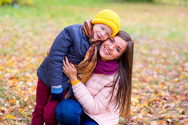 istock boy hugs his mother in autumn park 619063784