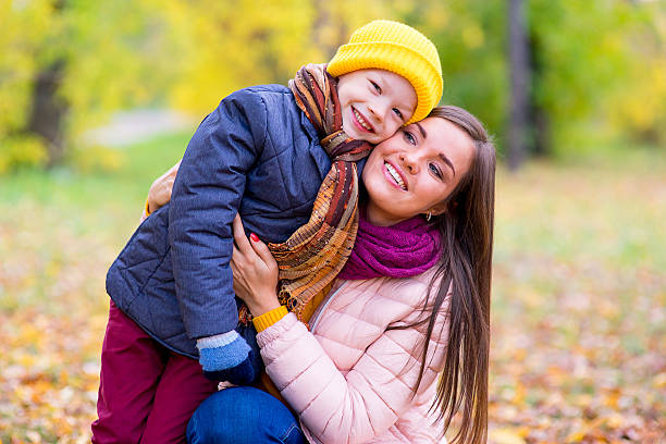istock boy hugs his mother in autumn park 619063944