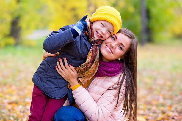 istock boy hugs his mother in autumn park 619064064