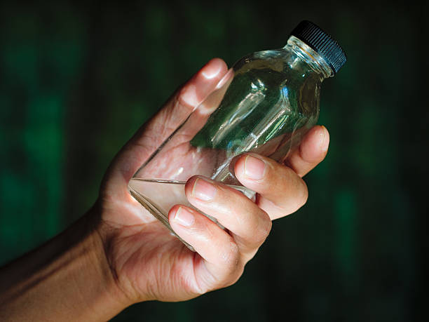 istock Hand holding a clear bottle with clear liquid like medicament 619064936