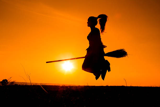 istock Silhouette of young witch flying on the broomstick 619065364