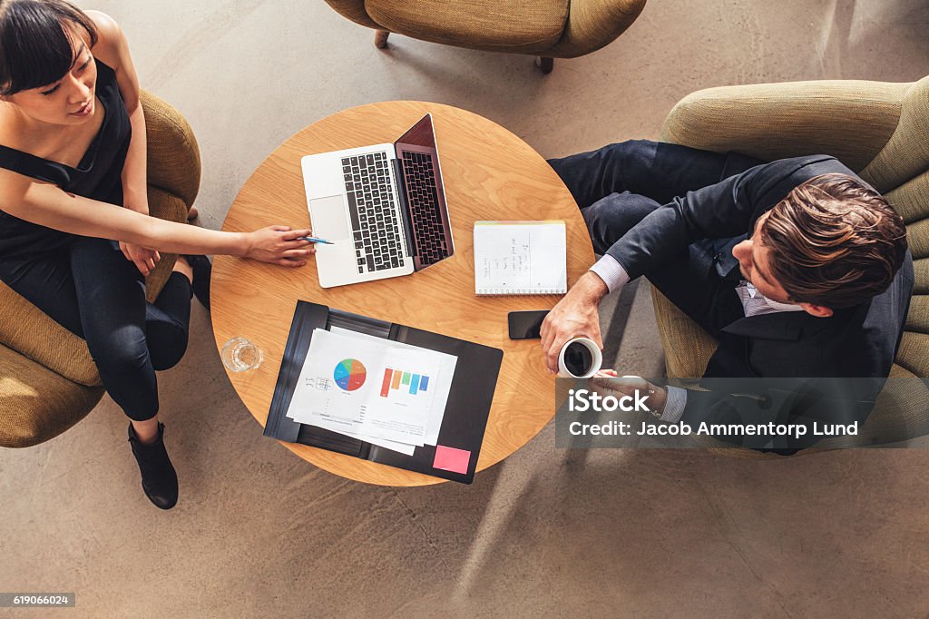 businesswoman meeting with businessman at office lobby Top view of businesswoman meeting with businessman at office lobby. Businessman and businesswoman discussing new project. Office Stock Photo