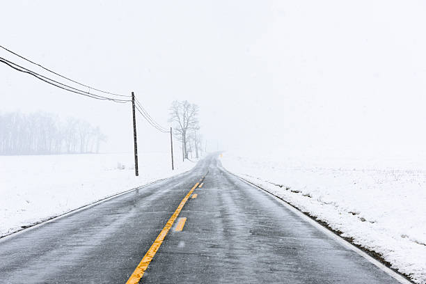 Empty Highway with Yellow Lines in Snow Storm stock photo