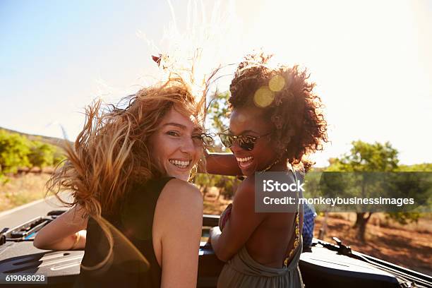 Two Women Standing In The Back Of Open Car Turning Stock Photo - Download Image Now - Friendship, Summer, Women