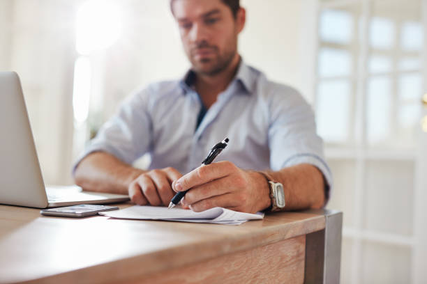 istock Young businessman at home office signing documents 619068264