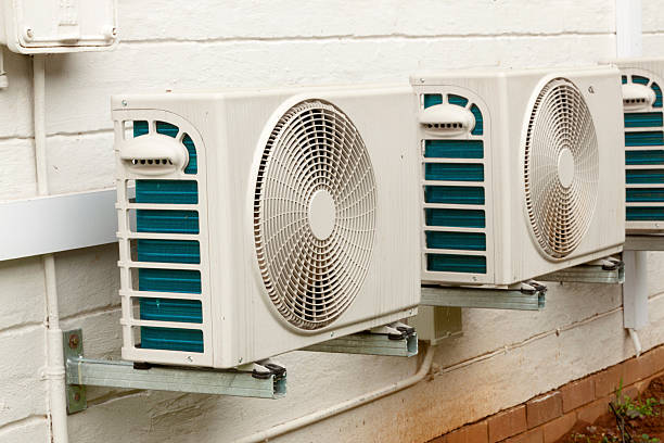 istock Weathered White Airconditioning Units Mounted on Exterior Home Wall 619069474