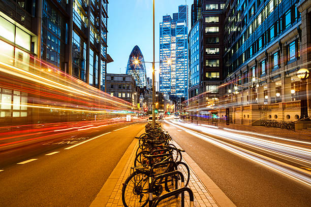 Traffic at Night in London, England Traffic at night in London, England, light trails from buses and cars are visible on both sides as well as illuminated office buildings. In the middle can be seen a lot of bicycles. Long exposure with tripod, 50 megapixel image. traffic car traffic jam uk stock pictures, royalty-free photos & images