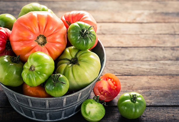 나무 테이블에 다채로운 유기농 토마토 - heirloom tomato organic tomato green tomato 뉴스 사진 이미지