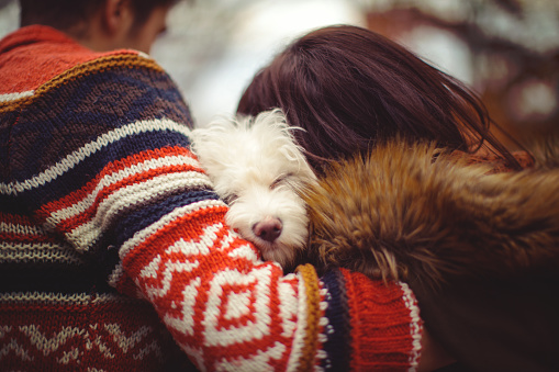 Young couple hugging with their sleepy dog
