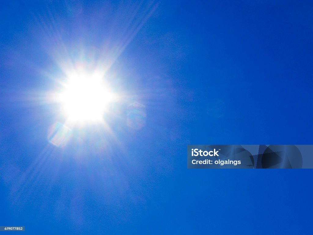Sun rays on blue sky Glare from sun rays against clear blue sky. Sun Stock Photo