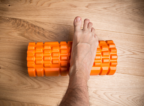 Orange massage roller tool used for foot massage