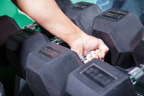 istock Man's hand holding heavy dumbbell 619078234