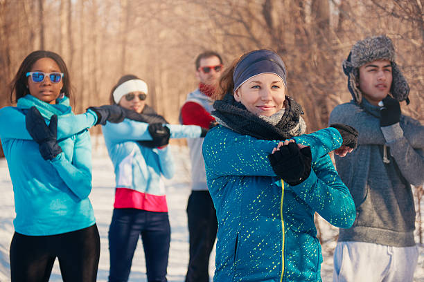 grupo de amigos que se extienden en la nieve en invierno - common women teenage girls exercising fotografías e imágenes de stock