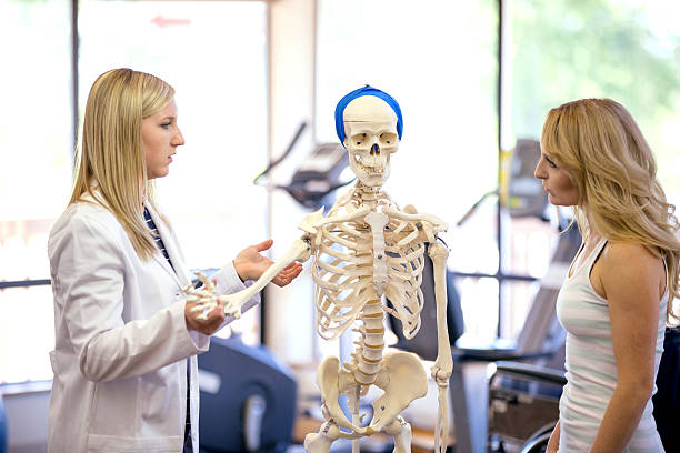istock Female physician teaching a female patient with a skeleton 619079276