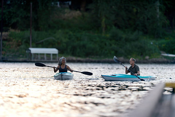 istock Diverse elderly couple kayaking on a river together at dusk 619080296