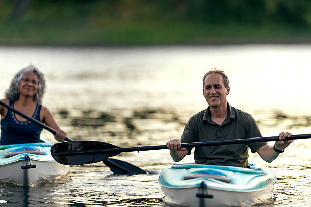 istock Elderly man smiling while kayaking with his wife on 619080314