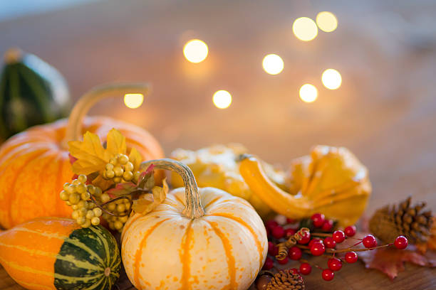 istock Thanksgiving table decorations of pumpkins, squash, grapes, and holly berries 619083322