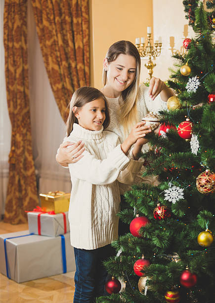 istock Portrait of mother decorating Christmas tree with daughter 619084550