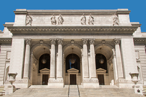 New York City, USA - February 20, 2016: People and traffic in front of the New York public library seen from 4th street.