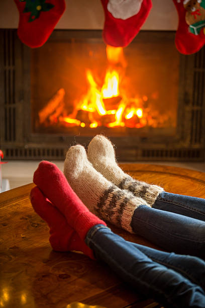 istock Family wearing woolen socks relaxing at burning fireplace 619086682