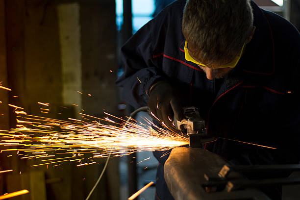 istock Worker grinding a metal part in his workshop. 619088014