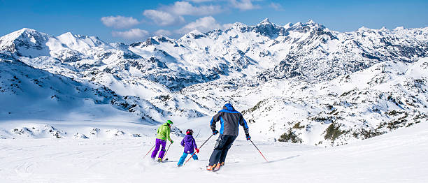 Family skiing Back view of a family with one child on ski slope. ski holiday stock pictures, royalty-free photos & images