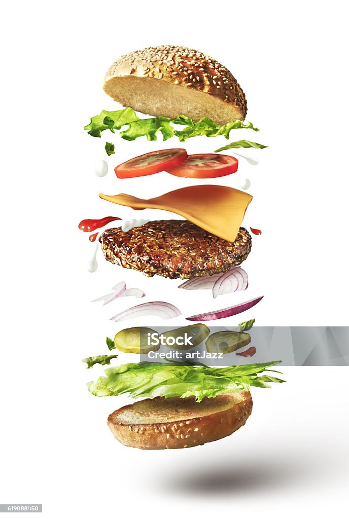 Delicious hamburger with flying ingredients Delicious hamburger with flying ingredients on white background Burger Stock Photo