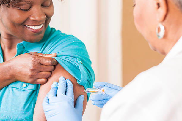 врач или медсестра дает вакцину против гриппа пациенту в клинике. - injecting flu virus cold and flu doctors office стоковые фото и изображения