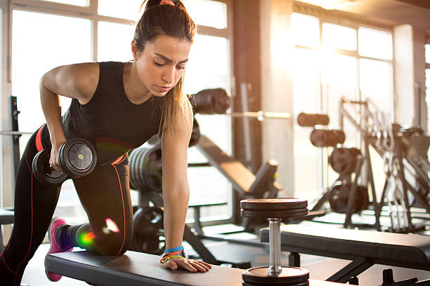 fitness girl lifting dumbbell in the morning. - egzersiz stok fotoğraflar ve resimler