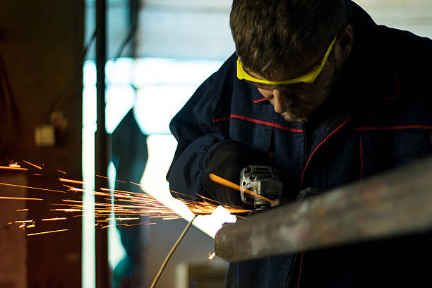istock Manual worker grinding steel table in production hall. 619089026