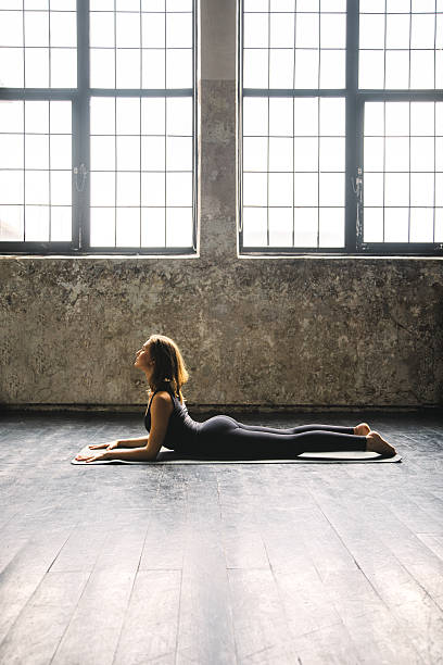 istock Young woman practicing yoga in urban loft: Sphinx Pose 619089032
