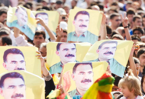 Van, Turkey - September 1, 2012: The crowd of the political meeting is showing the posters of Abdullah Ocalan, the leader of PKK, during the world peace day demonstration in Van, Turkey. Some of them are also making a peace sign. PKK stands for Kurdistan Workers Party and it carries out independence movement against Turkish State. This includes also armed struggle. Abdullah Ocalan is the indisputable leader of this movement.